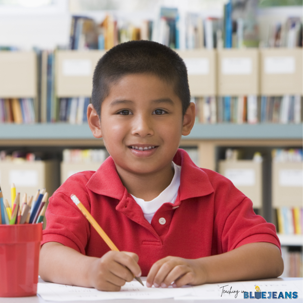 This image shows an elementary aged boy holding a pencil while smiling.