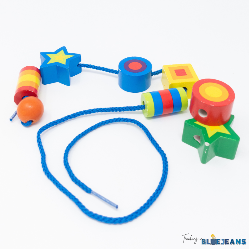 This image shows a stringing activity that students can use the strengthen fine motor skills. Colorful beads are strung on a blue shoestring.