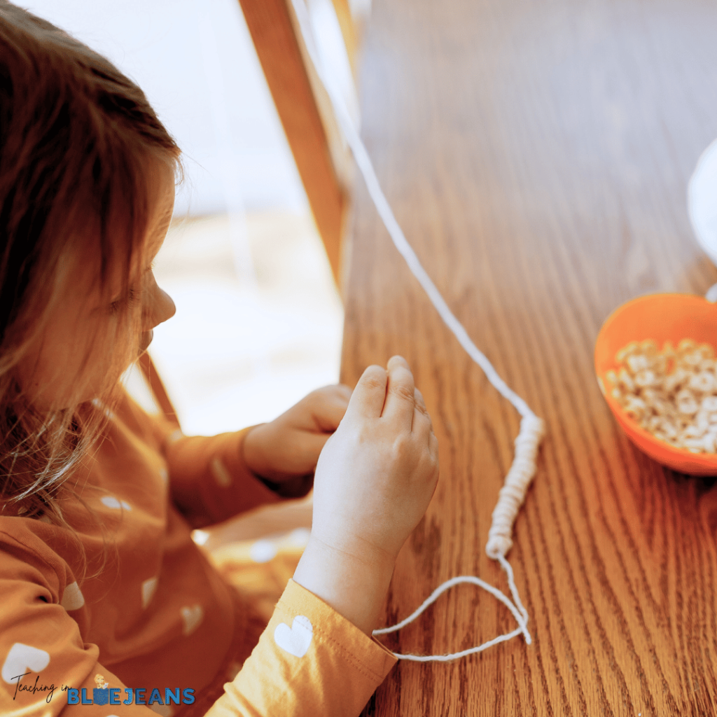 making a cereal necklace is a great way to practice this fine motor skill
