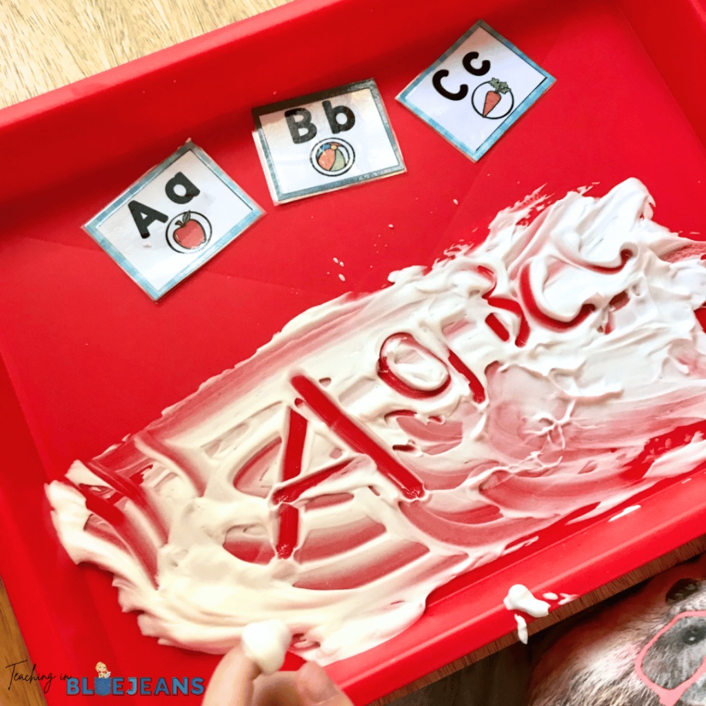 This photo shows a student writing letters in shaving cream as part of their fun prewriting activities.