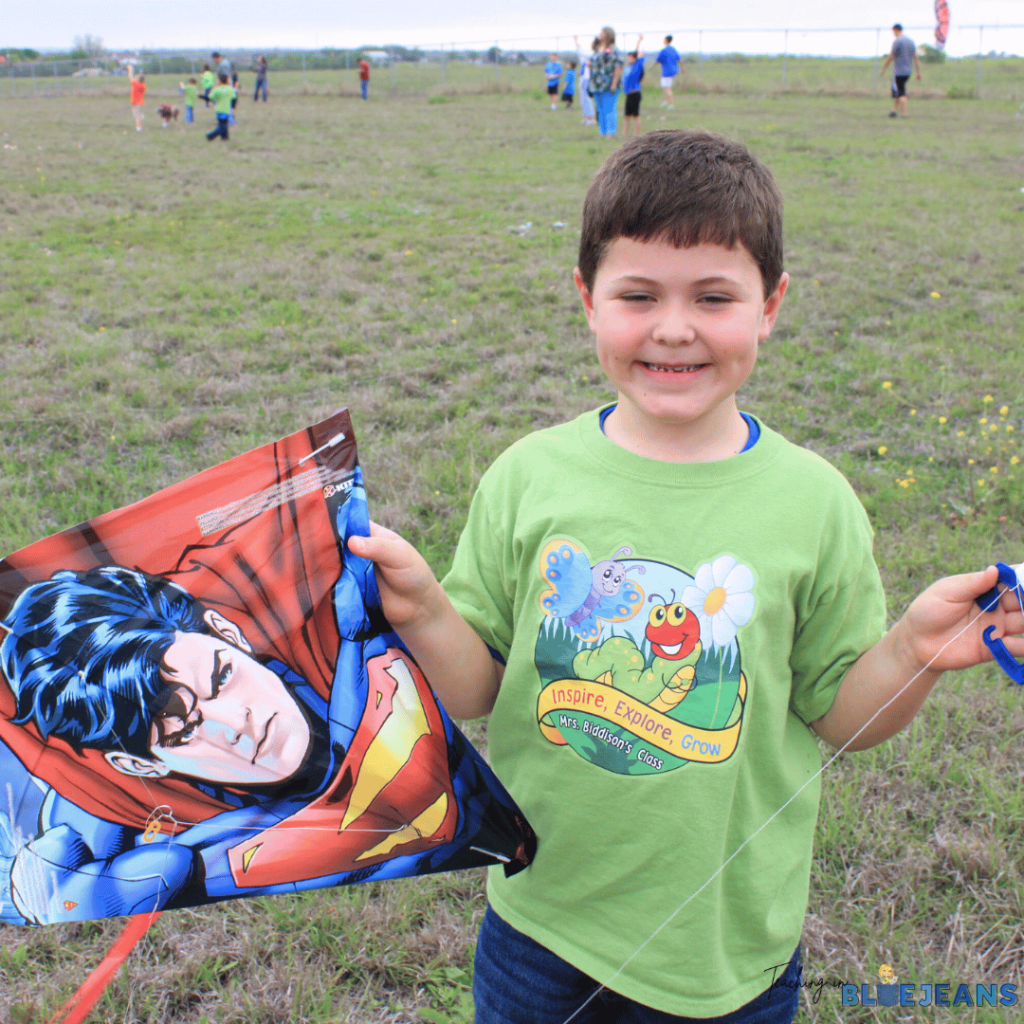 This picture shows a student holding a kite on the playground.